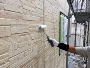 石積みデザインの外壁塗装・上塗り工程の様子