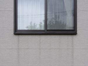 窓の下に延びる雨だれ汚れ